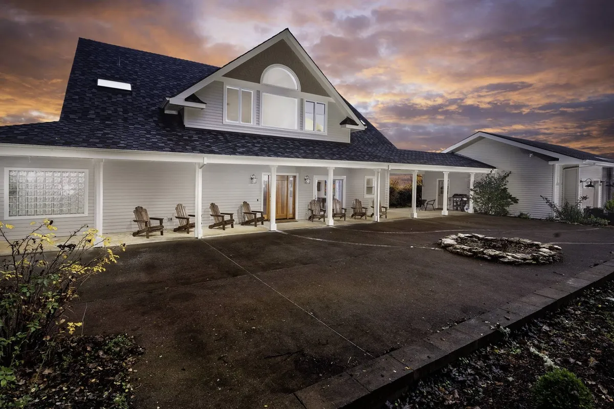 A charming front porch and landscaped garden with a fire pit area, offering spaces for relaxation, gatherings, and peaceful moments at sunset. The exterior setting highlights the seamless blend between the villa and its natural surroundings.